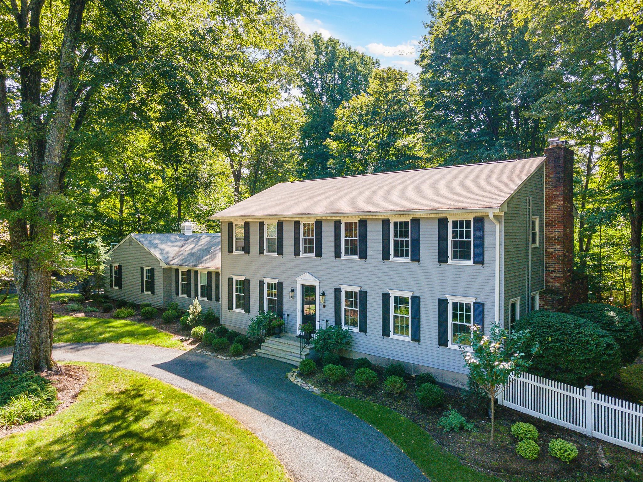 a aerial view of a house with swimming pool lawn chairs and a small yard