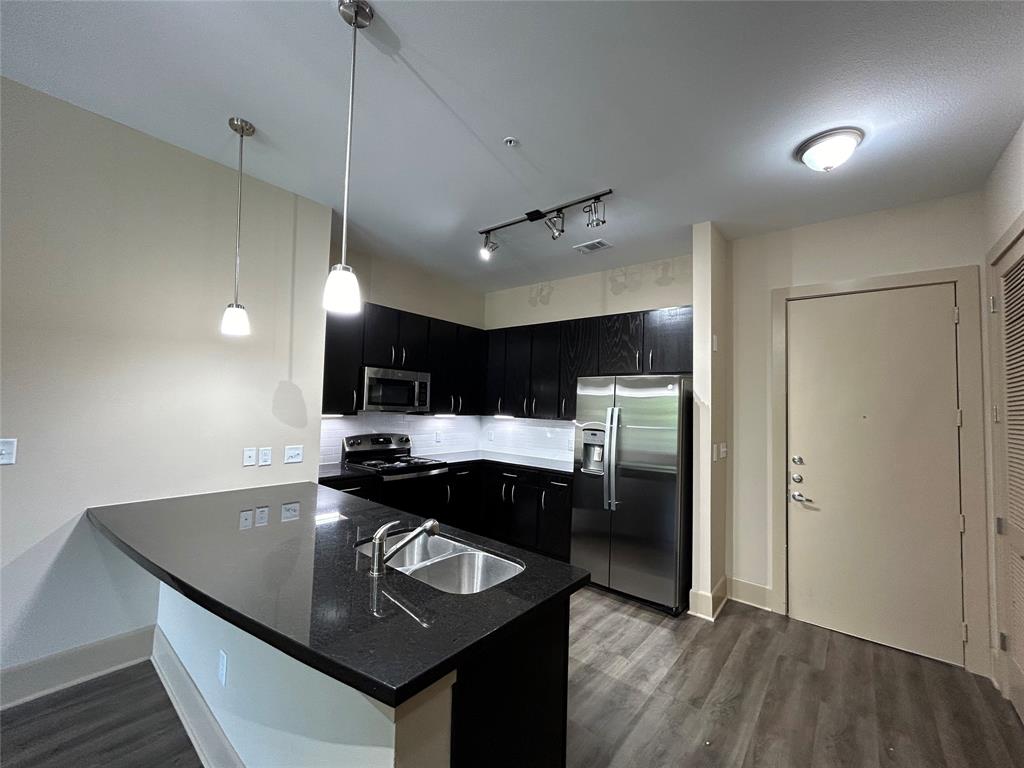 a kitchen with a sink a counter space and stainless steel appliances