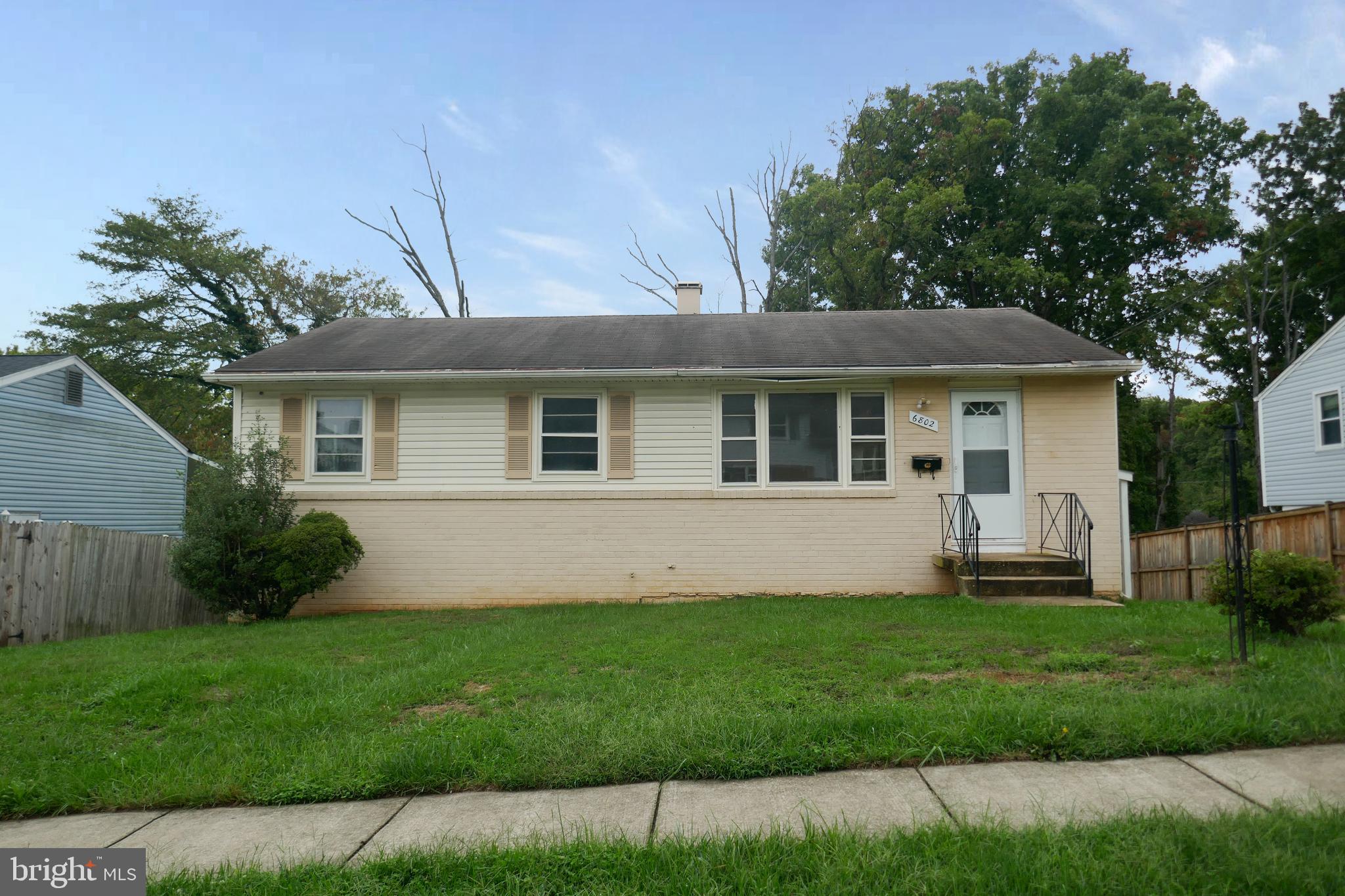 a front view of a house with a garden and yard