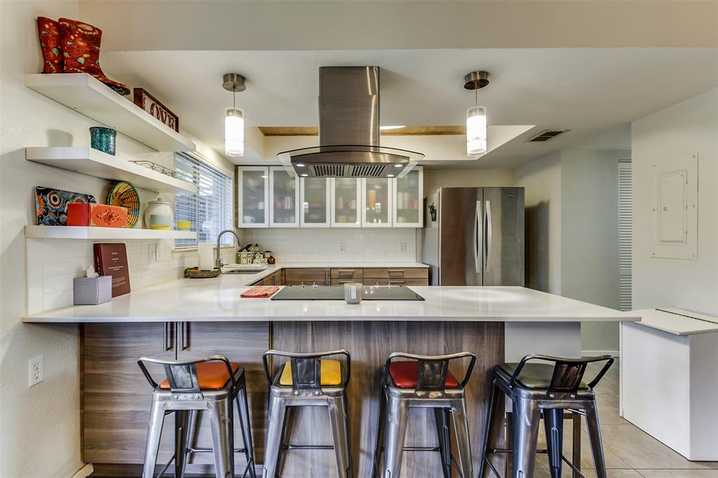 a kitchen with stainless steel appliances granite countertop a kitchen island and chairs in it