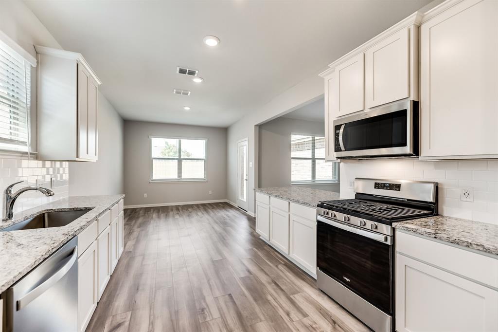 a kitchen with granite countertop a stove and a sink