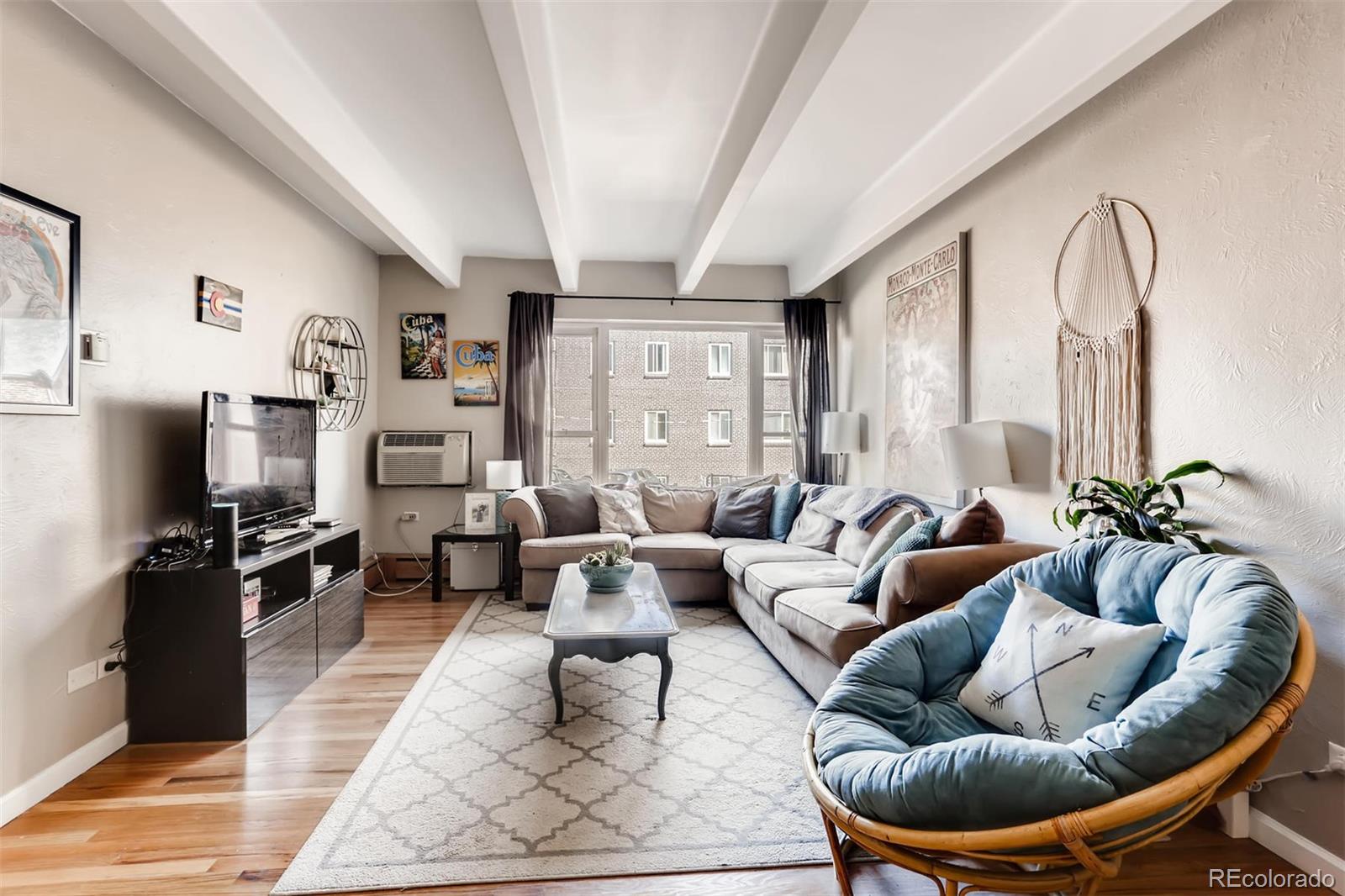 a living room with furniture a rug and a flat screen tv