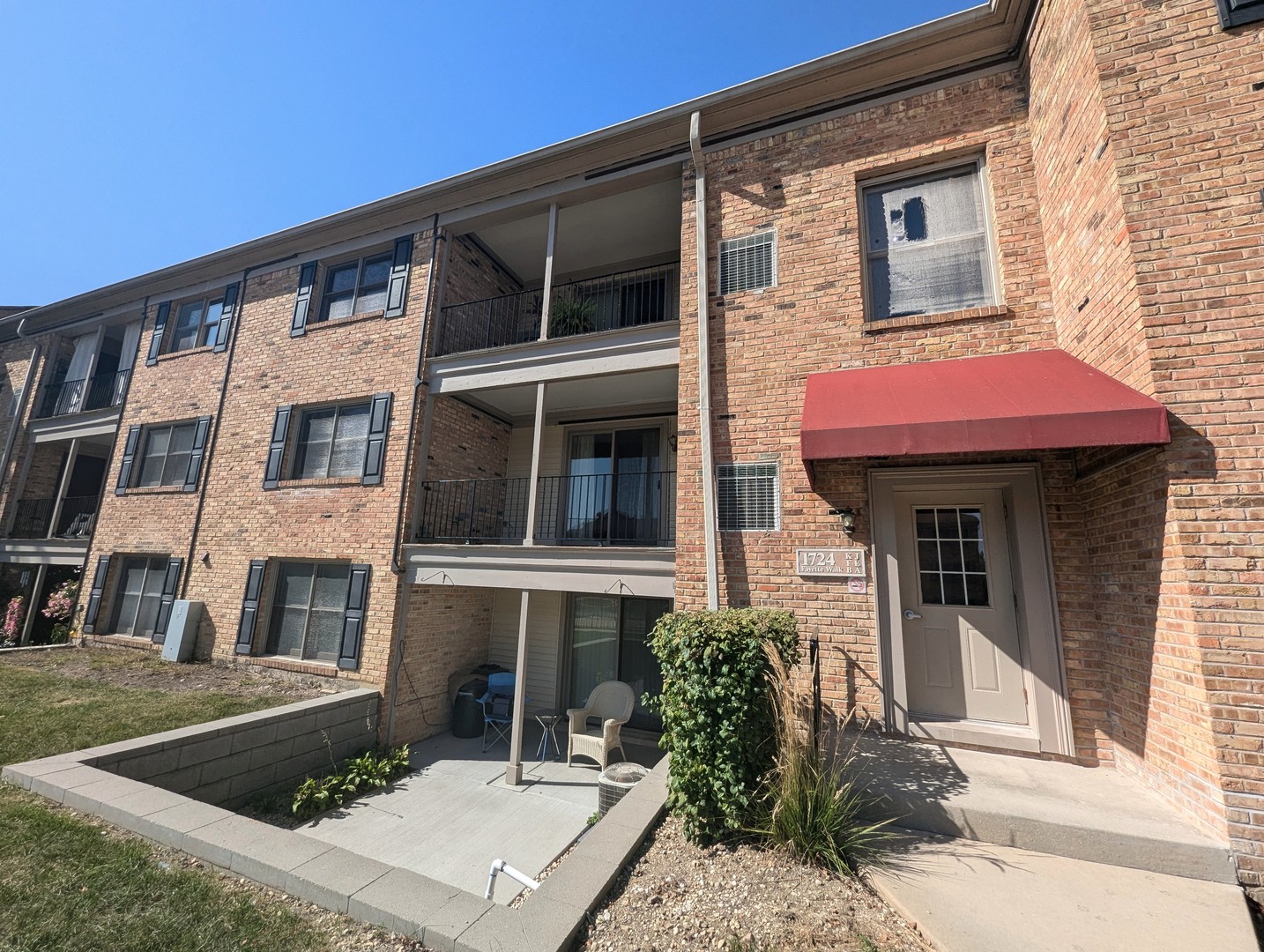 a front view of a residential apartment building with a yard