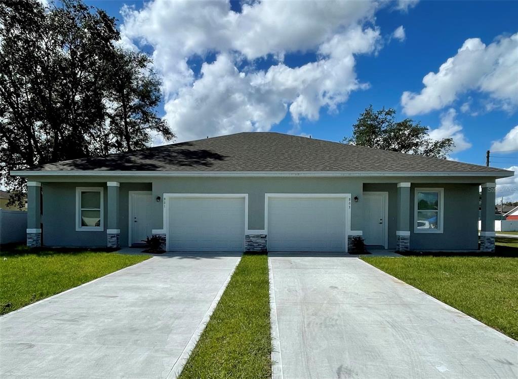 a front view of a house with a yard and garage