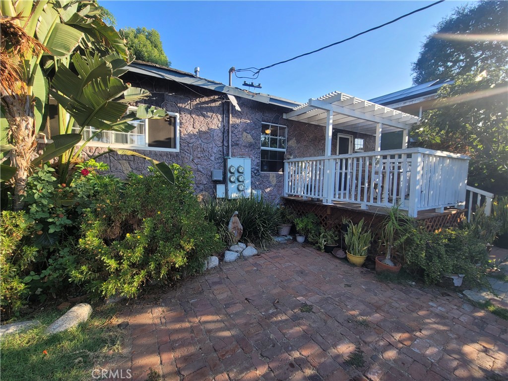 a view of a house with a yard and wooden deck