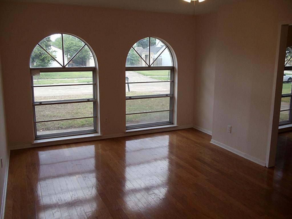 an empty room with wooden floor windows and wooden floor