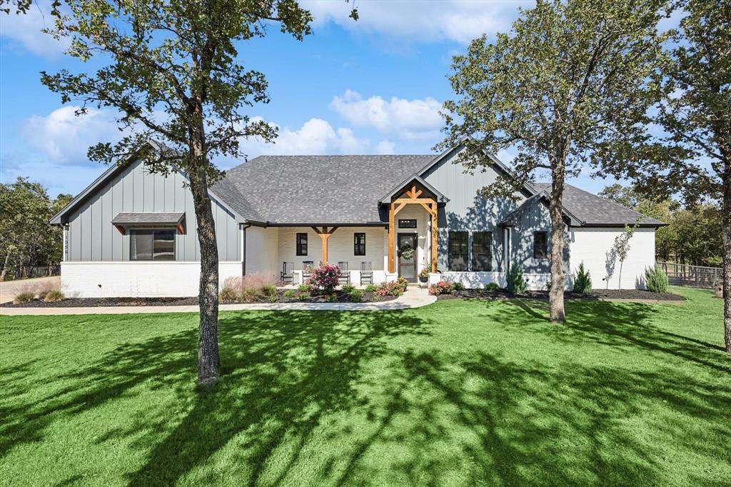 a front view of a house with yard and green space