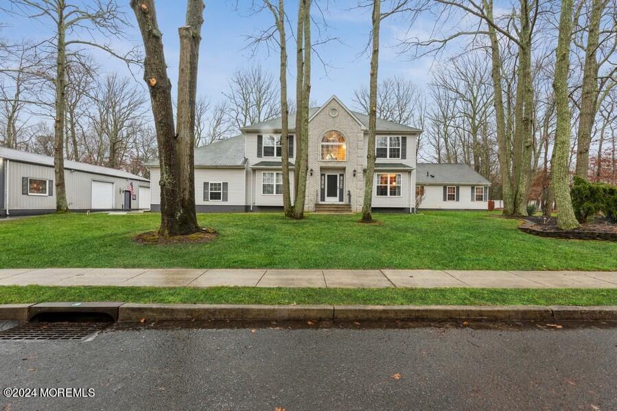 a front view of a house with a yard and trees