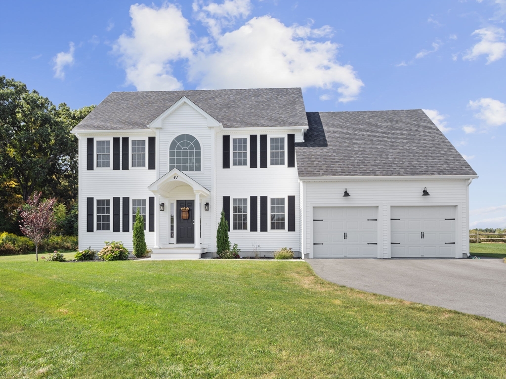 a front view of a house with a garden and yard