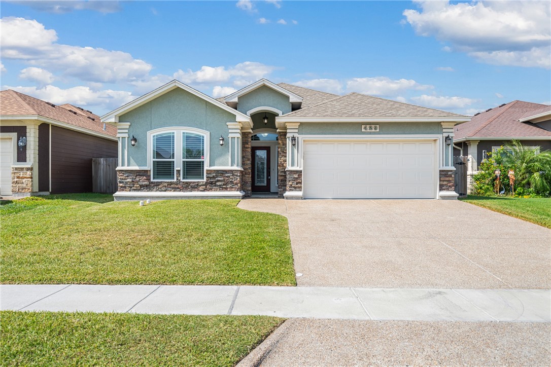 a front view of a house with a yard and garage