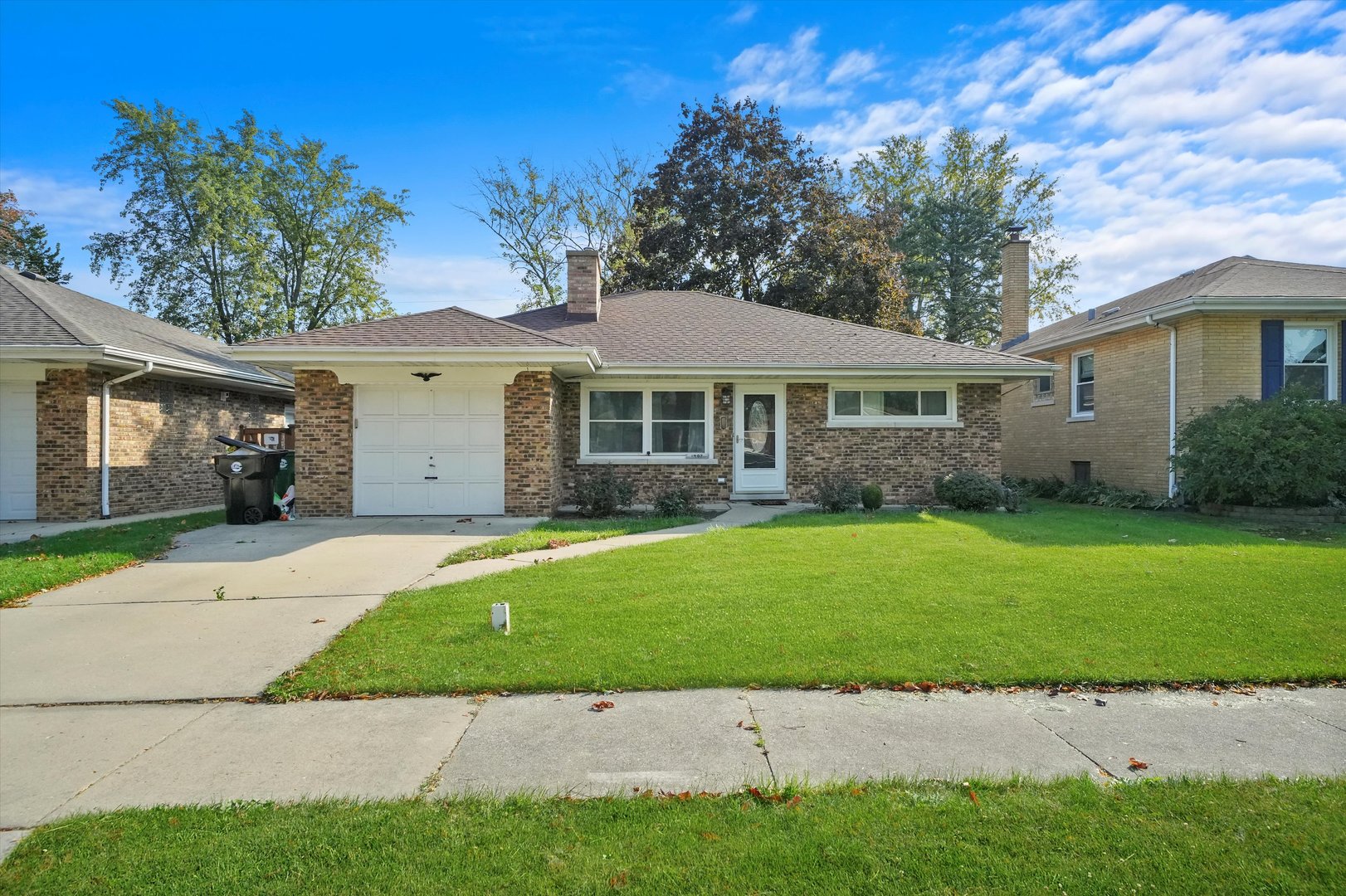 a front view of a house with a garden and yard