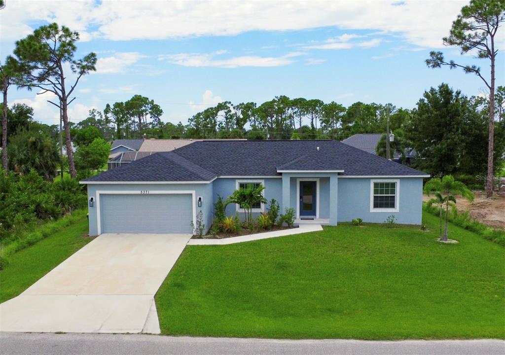 a front view of a house with yard and green space