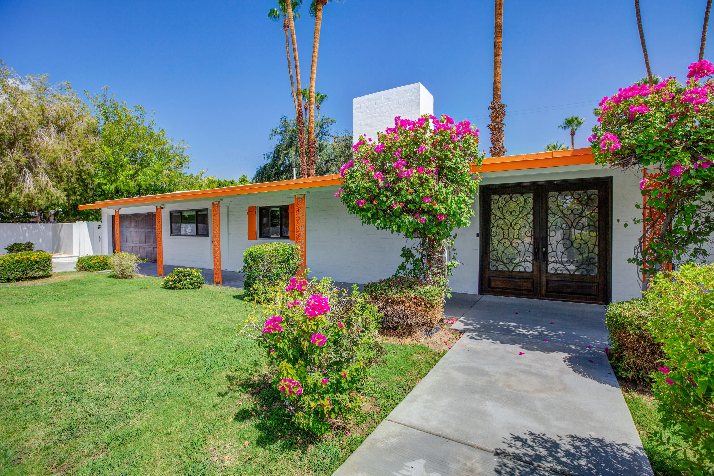 a front view of a house with a yard and fountain