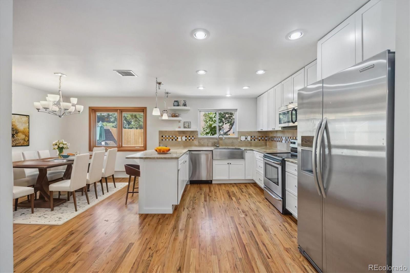 a kitchen with a refrigerator and wooden floor