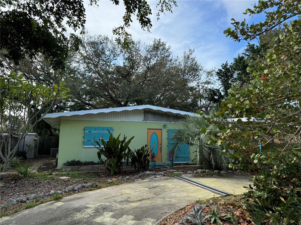 a view of a house with potted plants and large trees