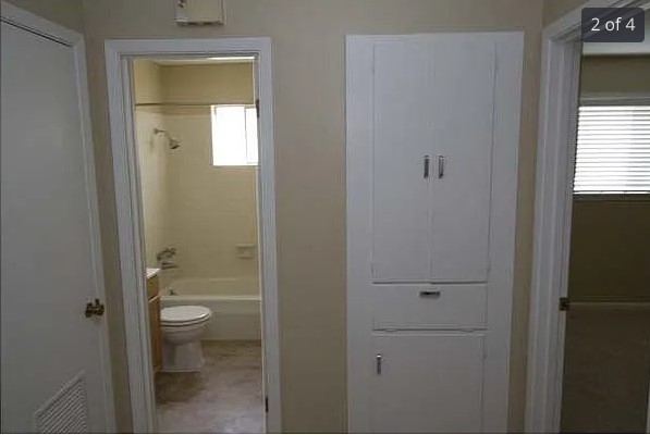 a bathroom with a granite countertop toilet a sink and mirror