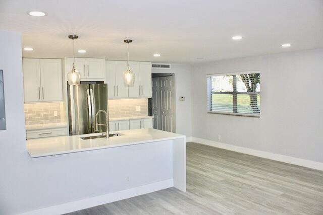 a room with kitchen island a sink wooden floor and glass door