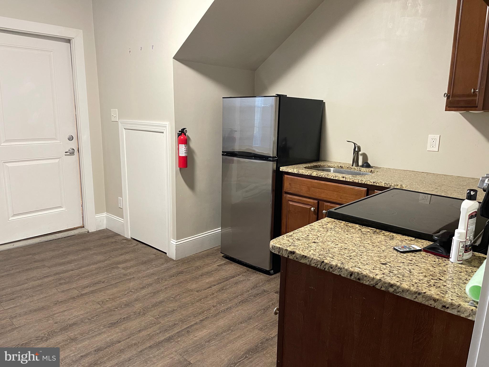 a kitchen with a wooden floor and refrigerator