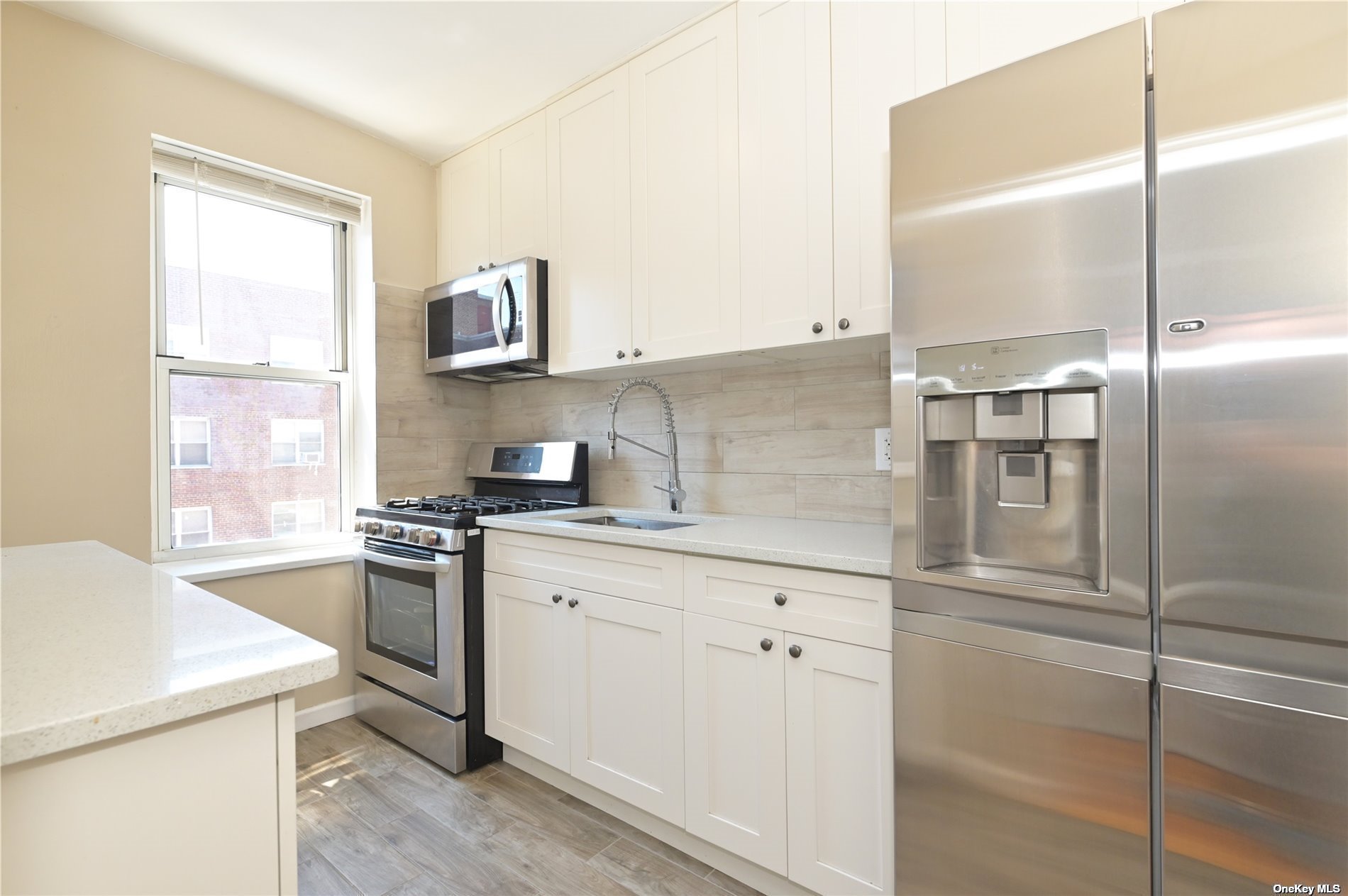 a kitchen with granite countertop a sink stainless steel appliances and cabinets