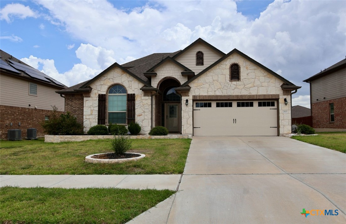 a front view of a house with a yard and garage