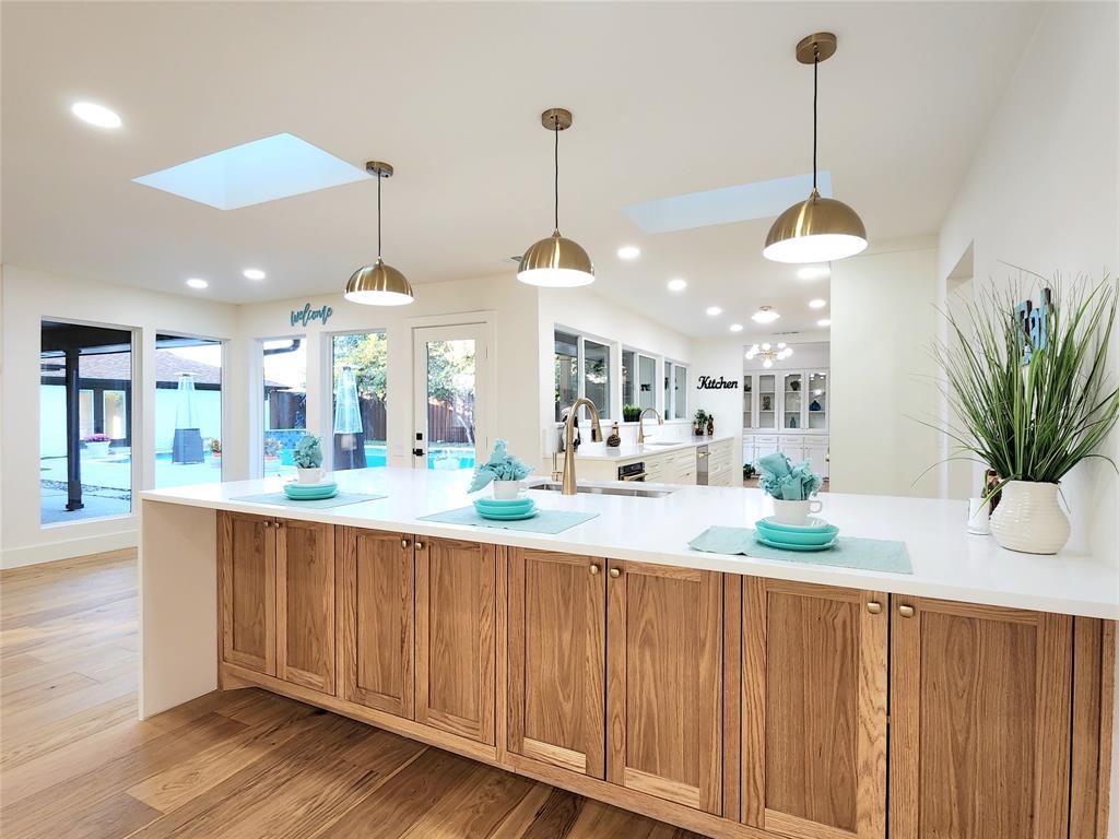 a dining room with wooden floor a chandelier a wooden table and chairs