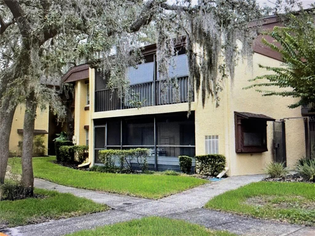 a front view of a house with a yard and potted plants