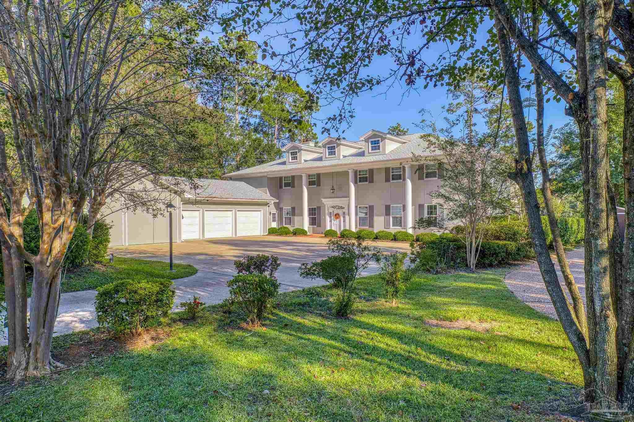 a view of a house with a yard patio and a large tree