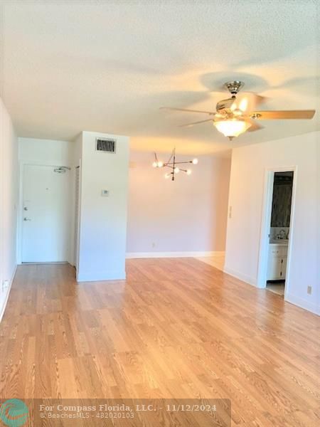 a view of a big room with wooden floor and cabinet