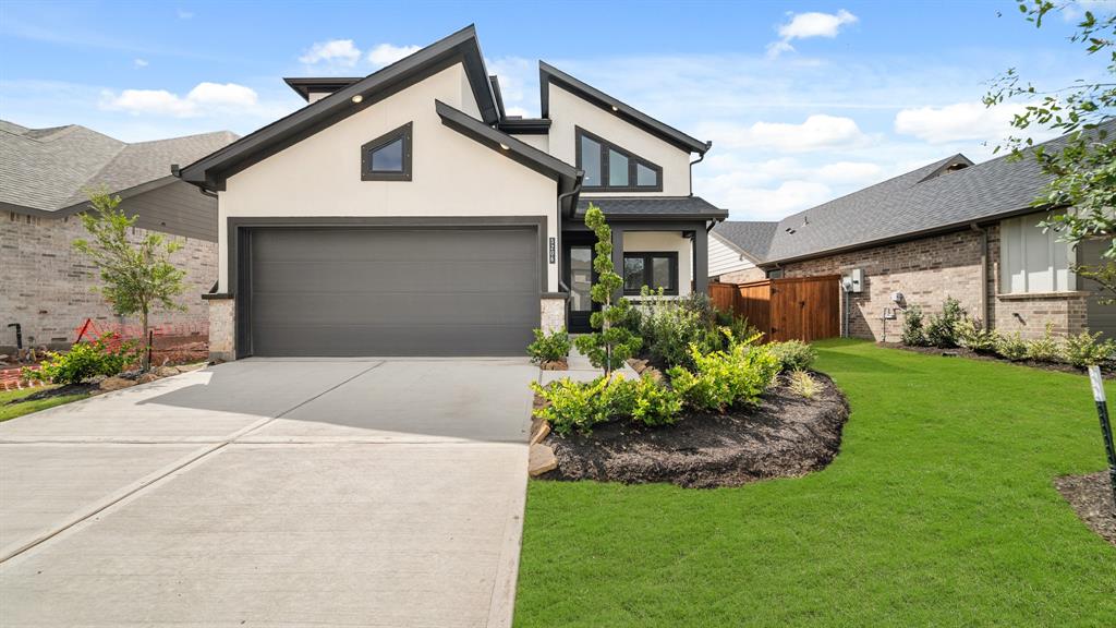 a front view of a house with a garden and plants