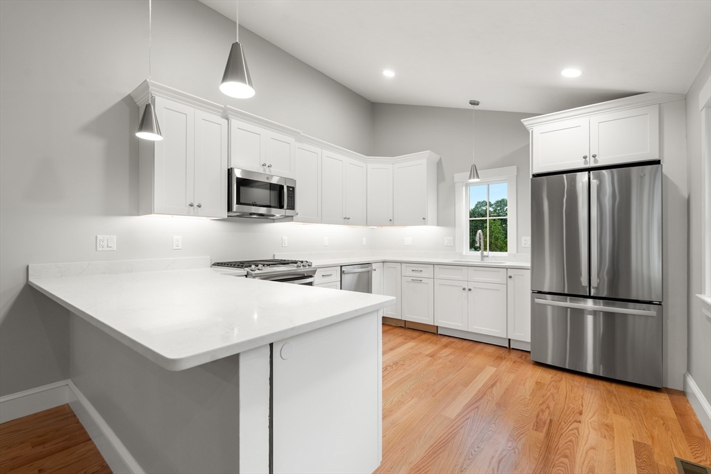 a kitchen with a refrigerator and a stove top oven