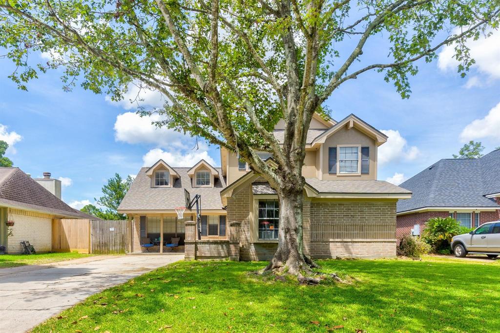 a front view of a house with a yard and trees