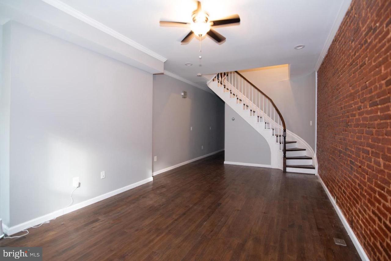 a view of a hallway with wooden floor and staircase