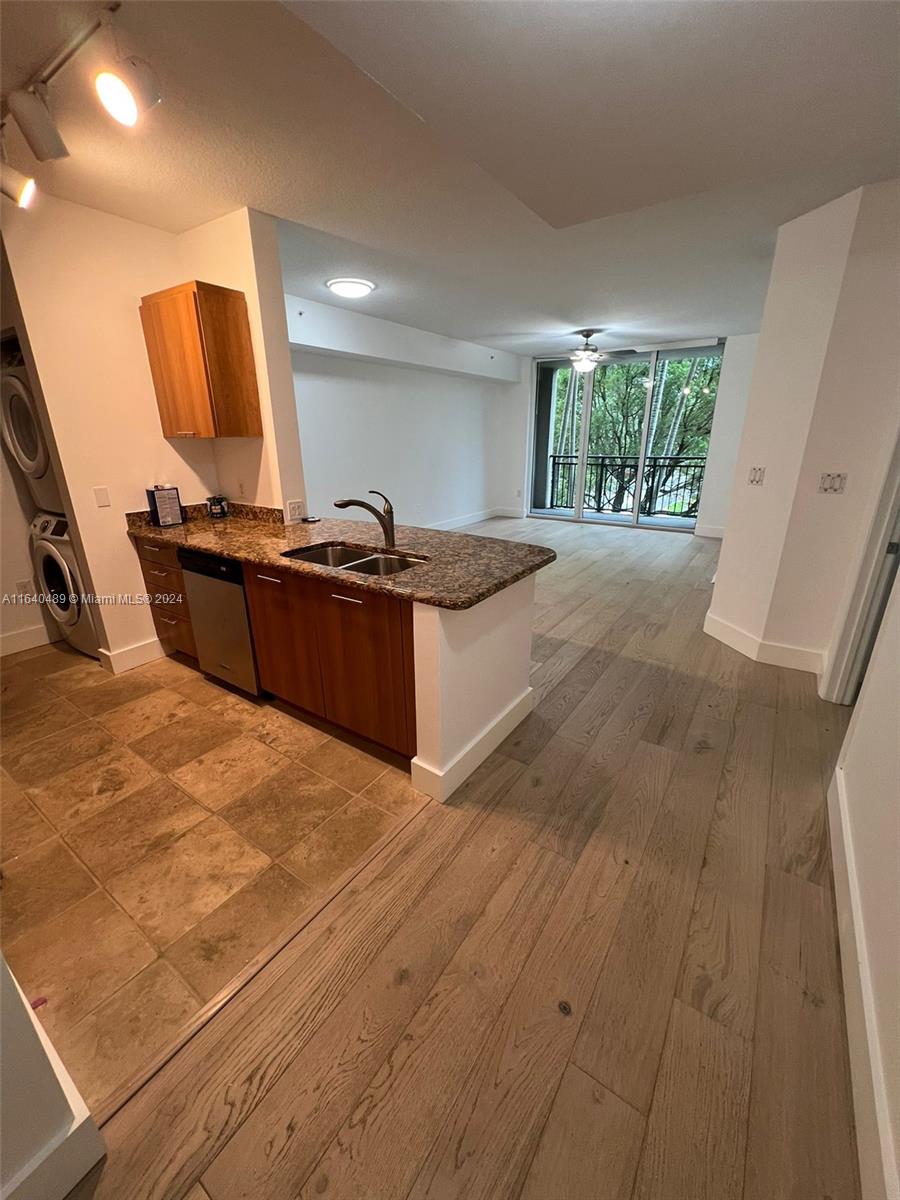 a kitchen with kitchen island granite countertop a sink stove and wooden floor