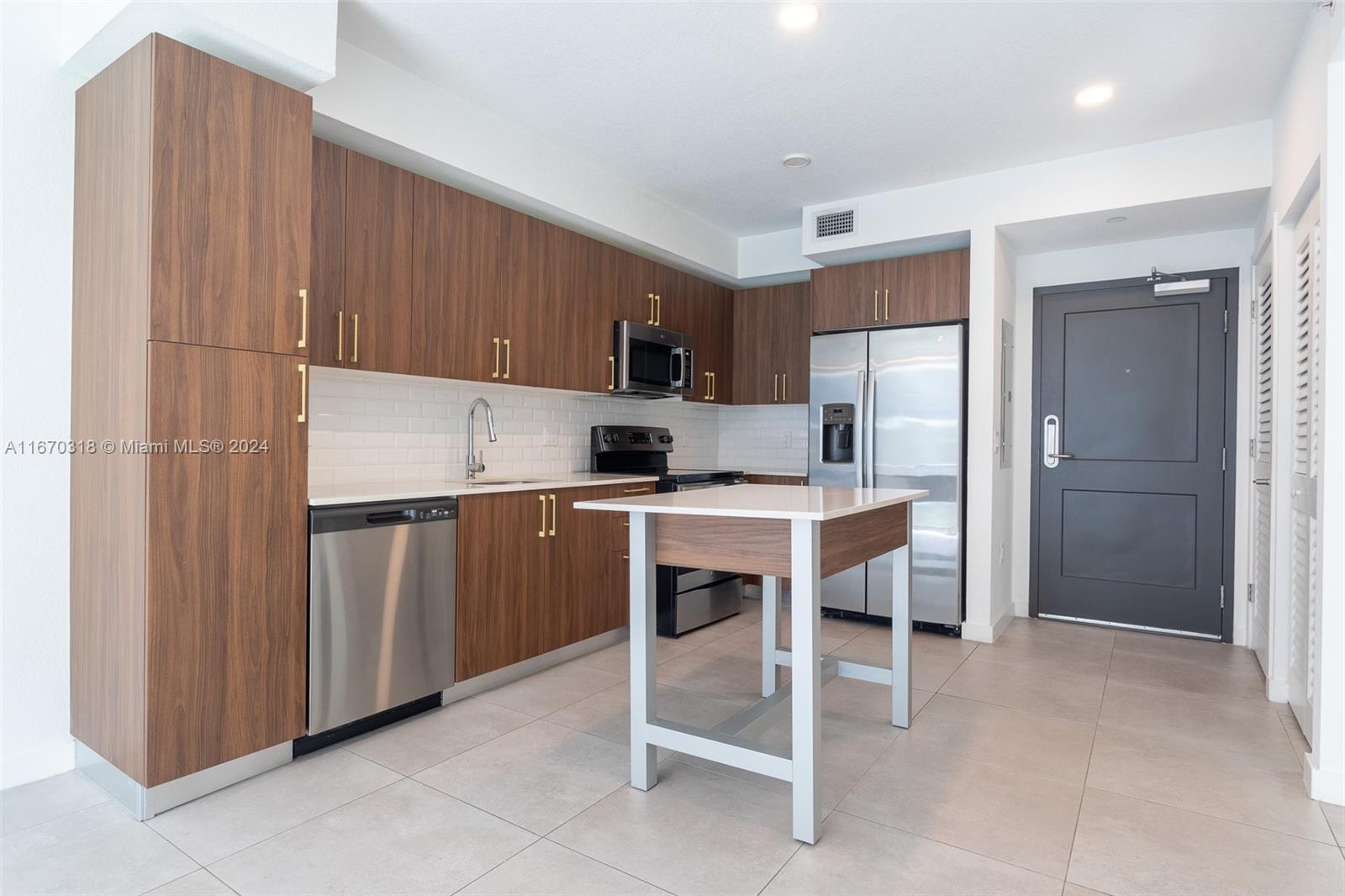 a kitchen with a refrigerator a sink and cabinets