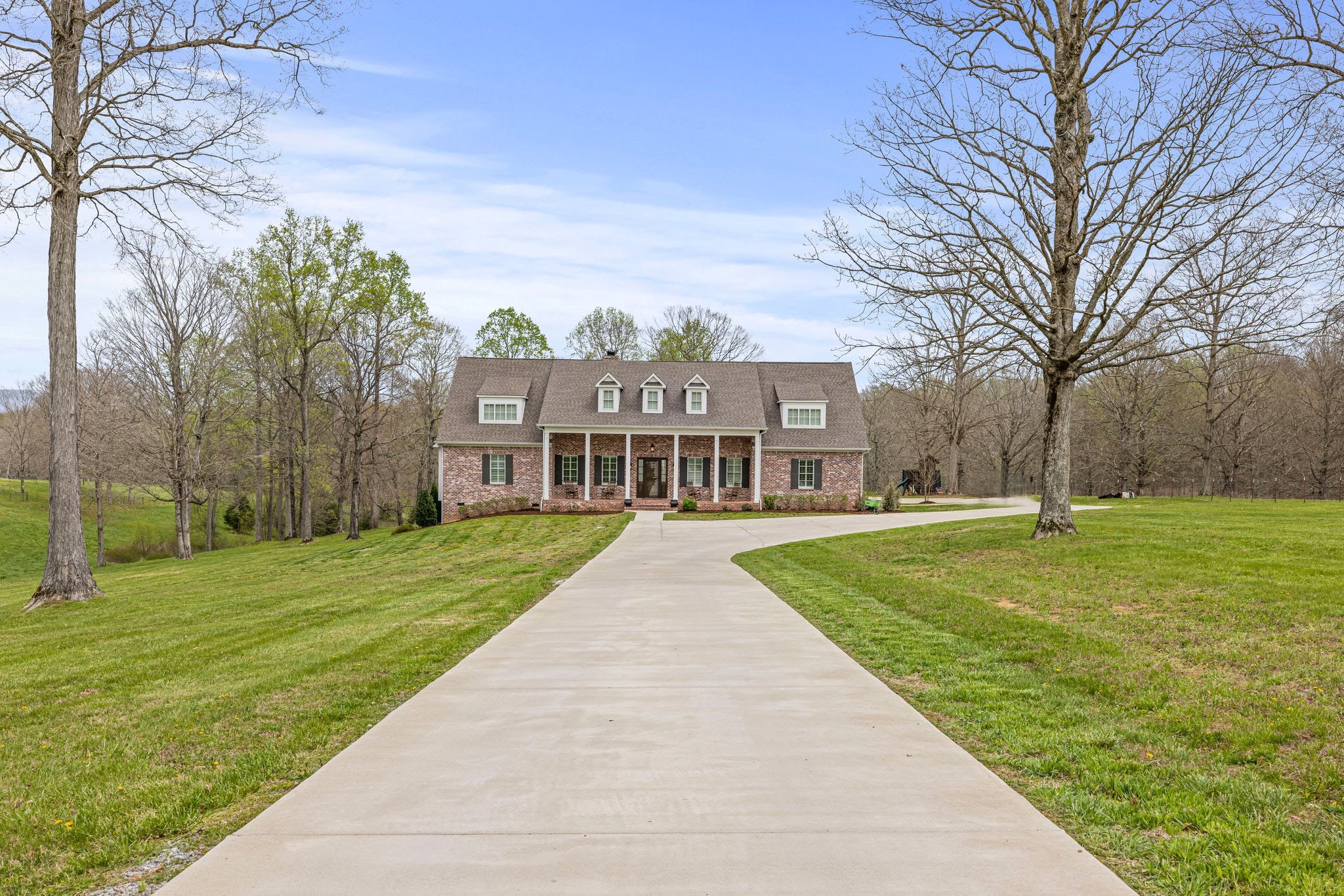 a view of a big yard next to a brick house with a big yard