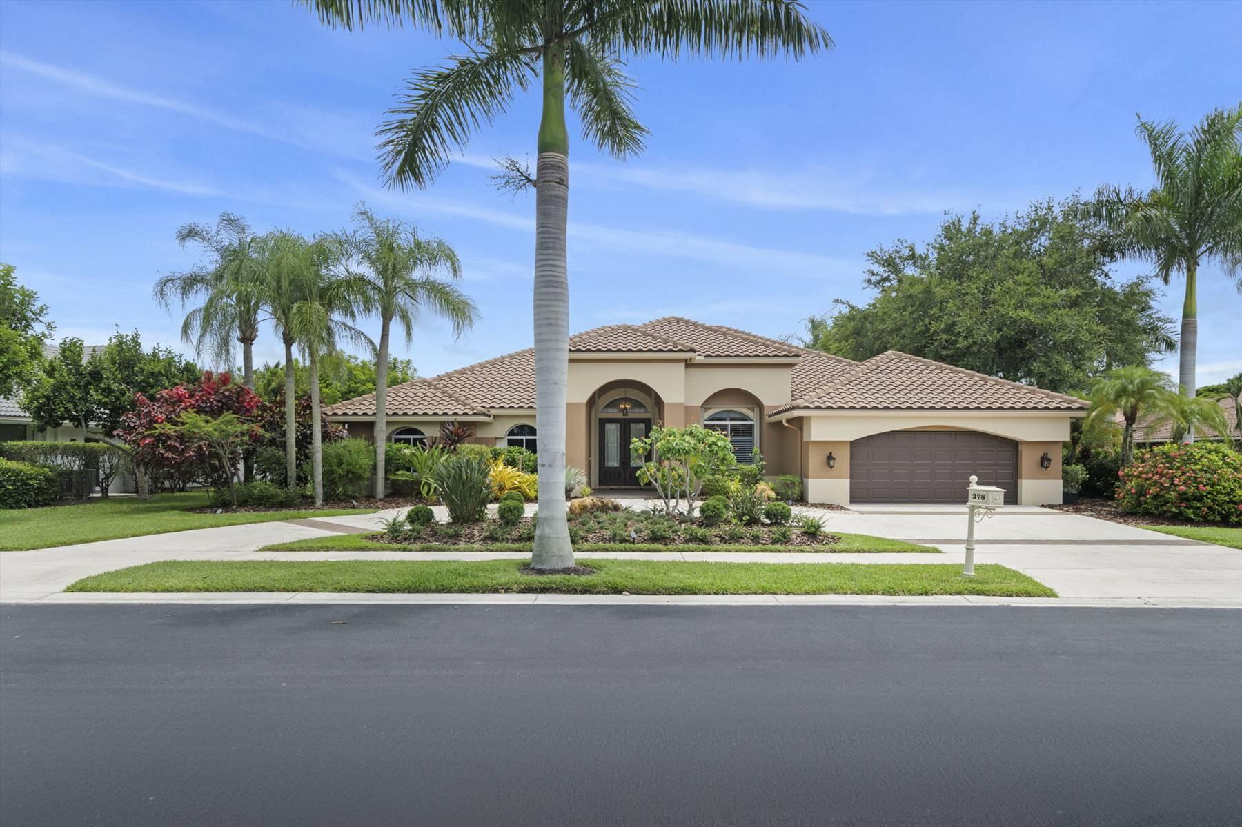 a yellow house with palm trees in front of it