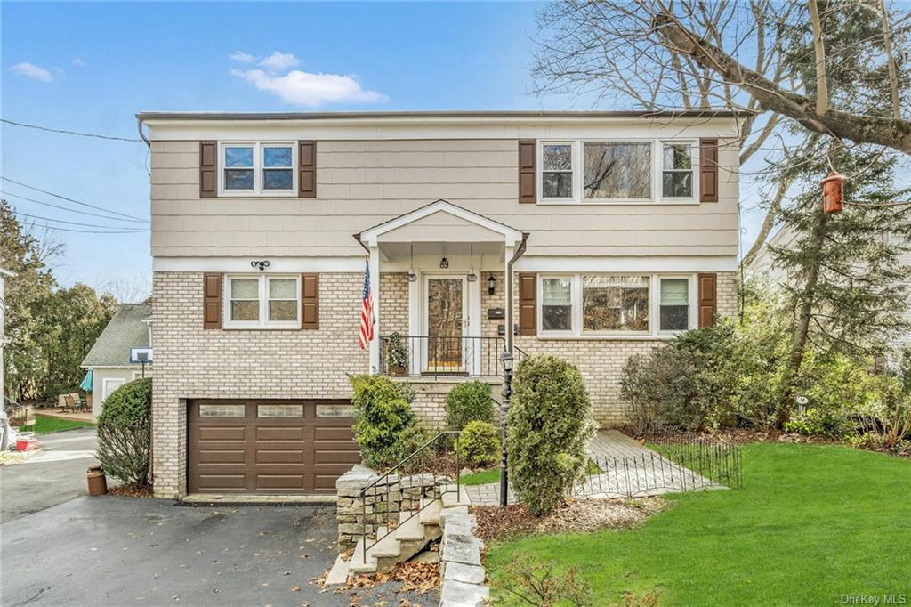 View of property featuring a front yard and a garage