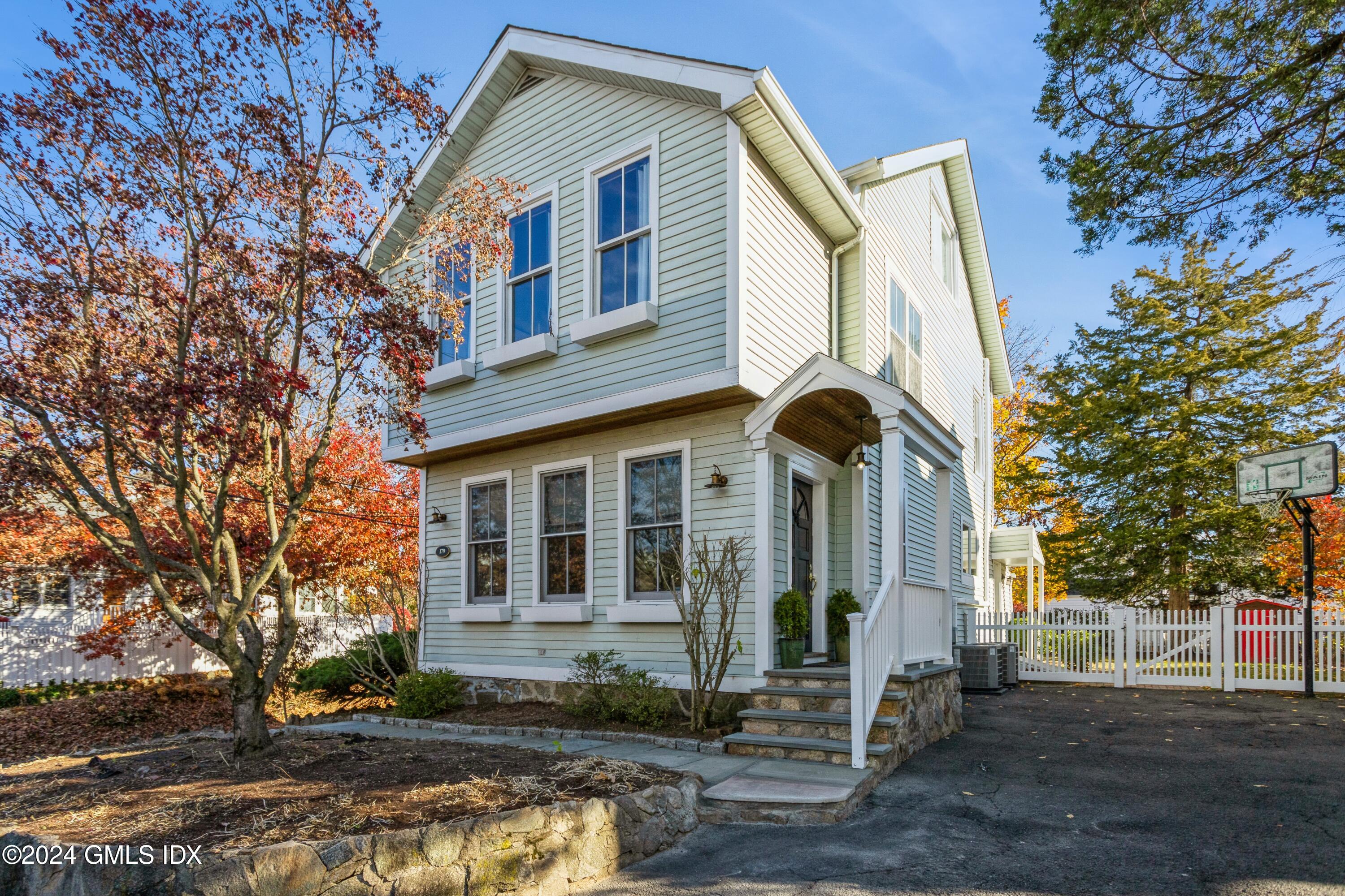 a front view of a house with a tree