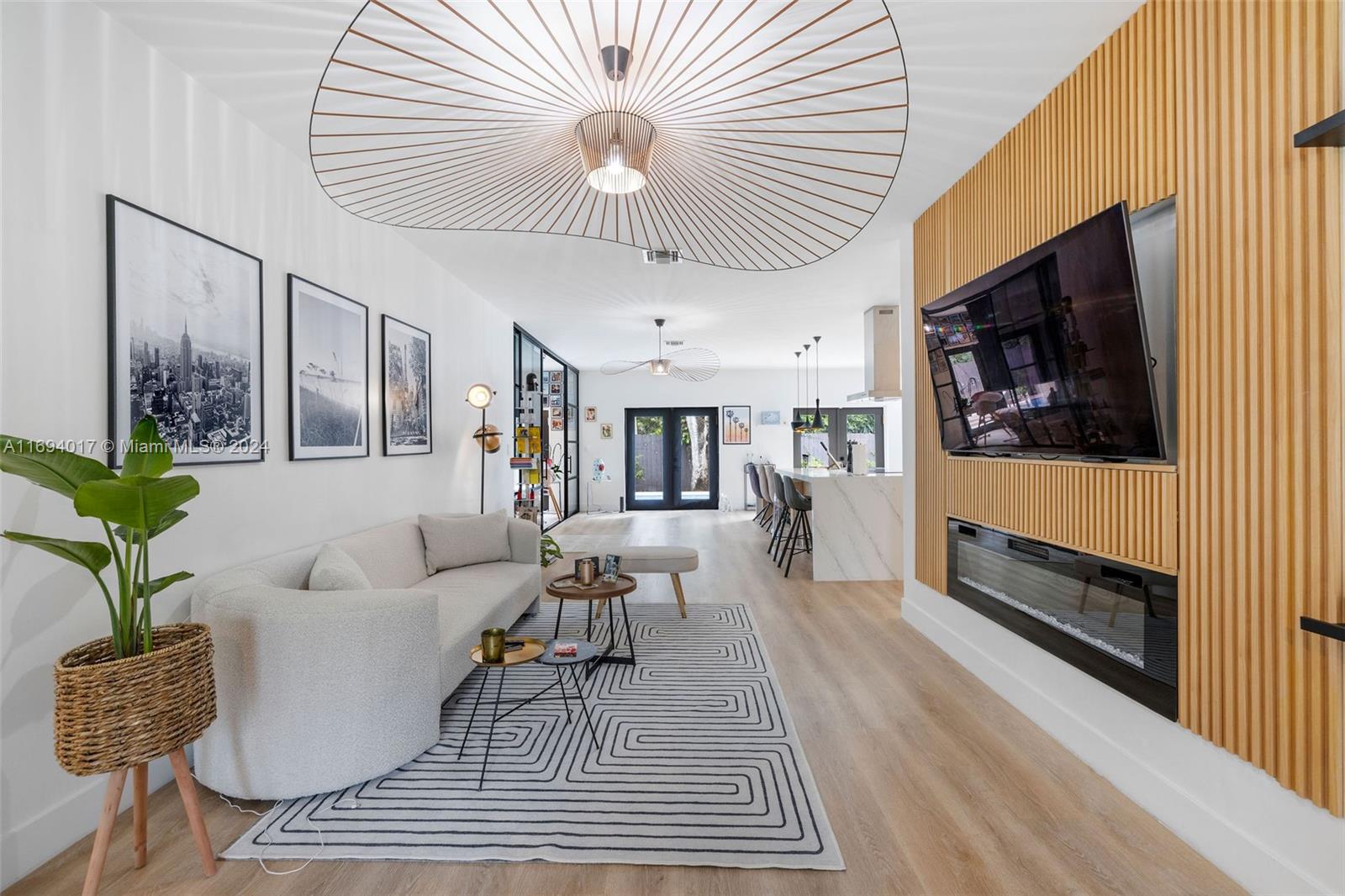 a living room with furniture a flat screen tv and a wooden floor