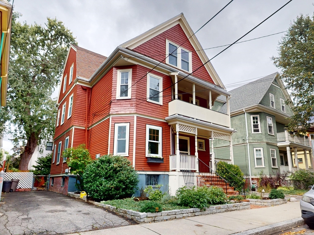 a front view of a house with a yard and potted plants