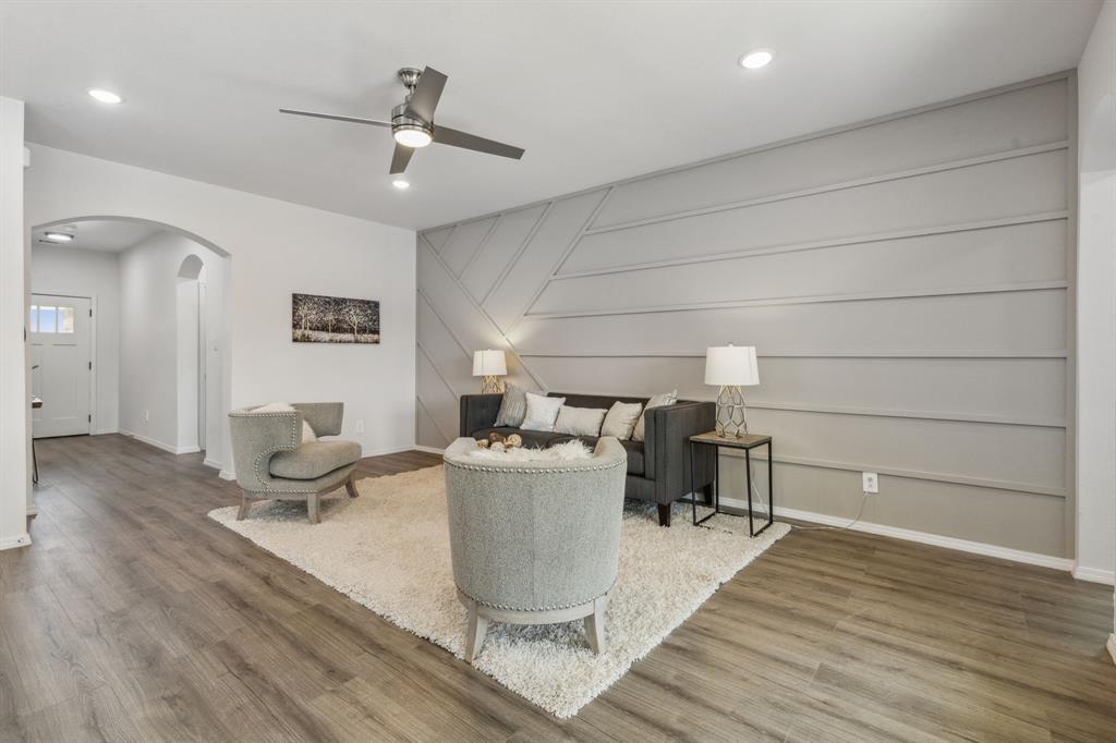 Living room with wood-type flooring and ceiling fan