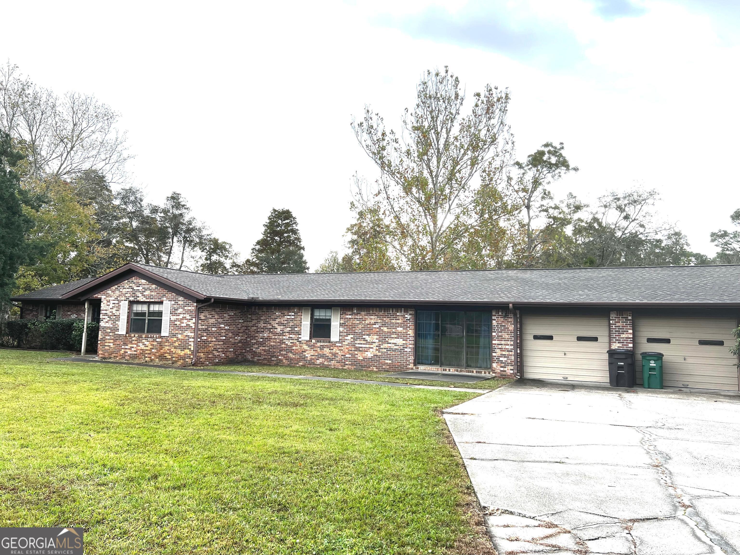 a front view of a house with a garden and trees