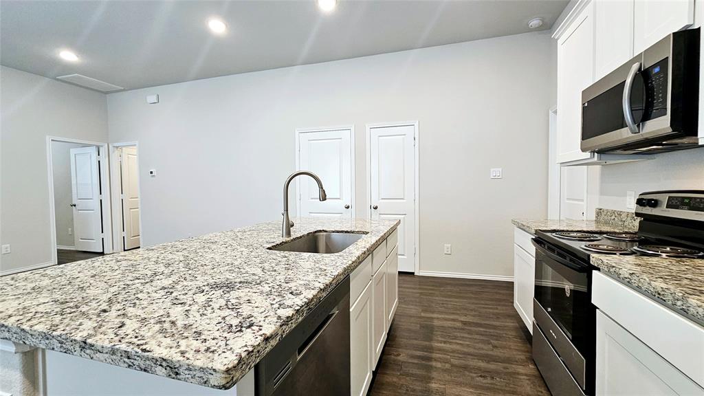 a kitchen with stainless steel appliances granite countertop a sink and stove