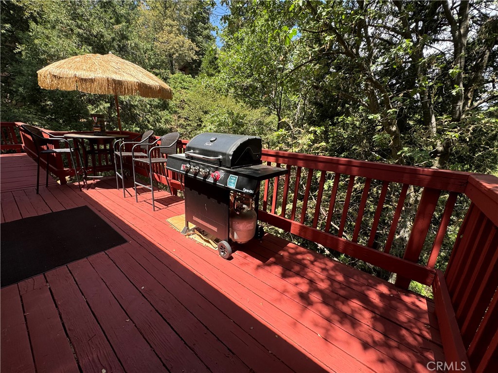 a view of a roof deck with wooden floor and barbeque oven