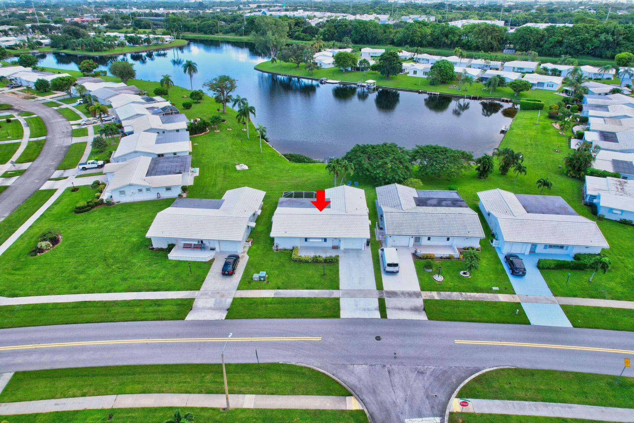 an aerial view of a house with a garden and lake view