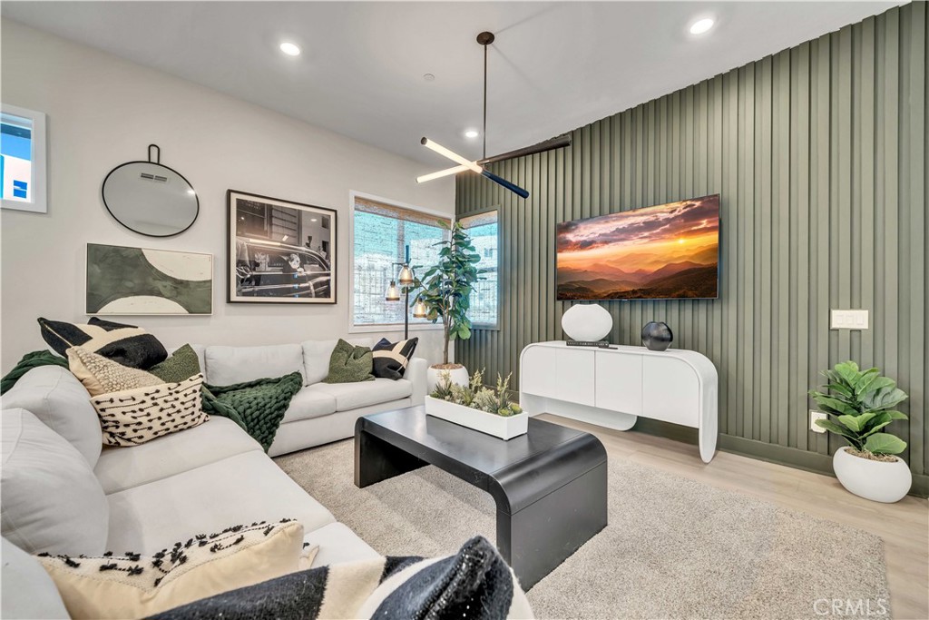 a living room with furniture a chandelier and a flat screen tv