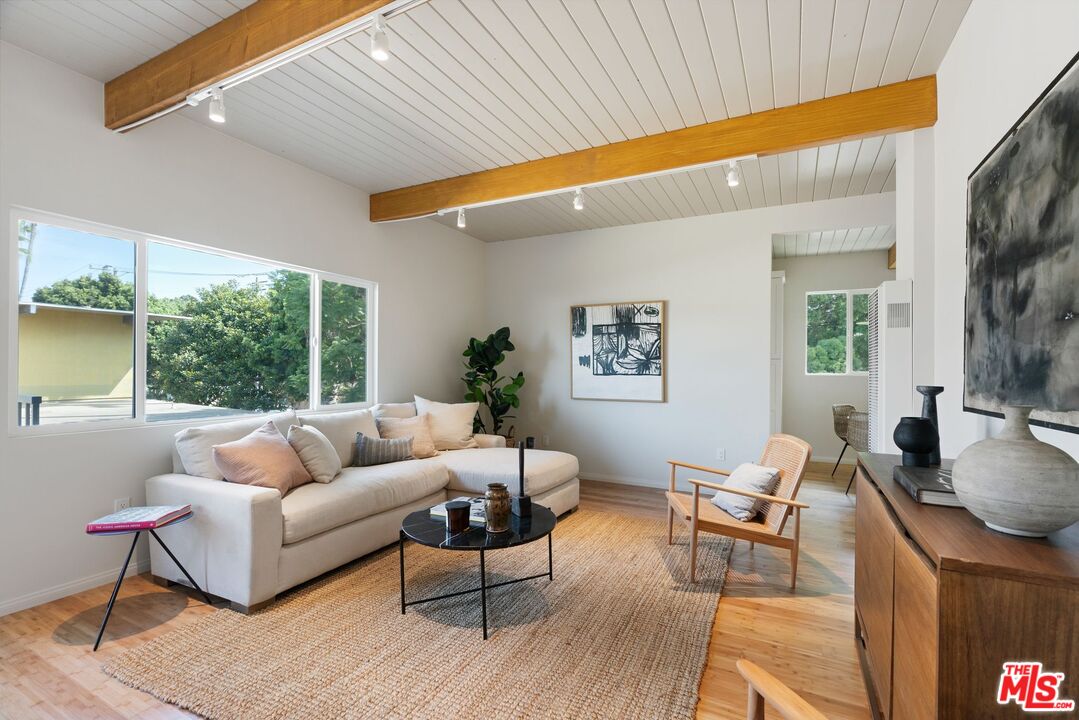 a living room with furniture a flat screen tv and a large window