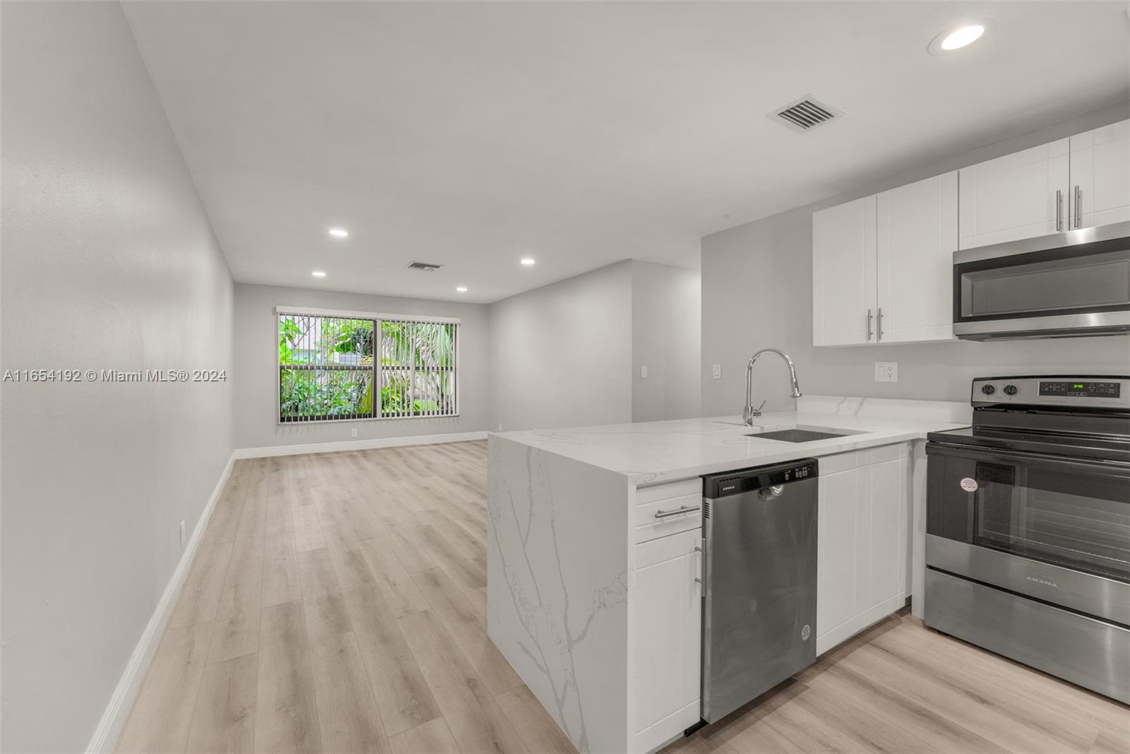 a kitchen with a sink a stove and cabinets