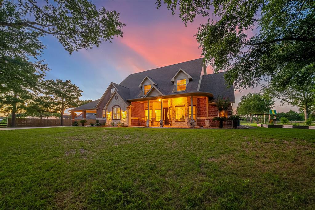 a view of a big house with a big yard and large trees