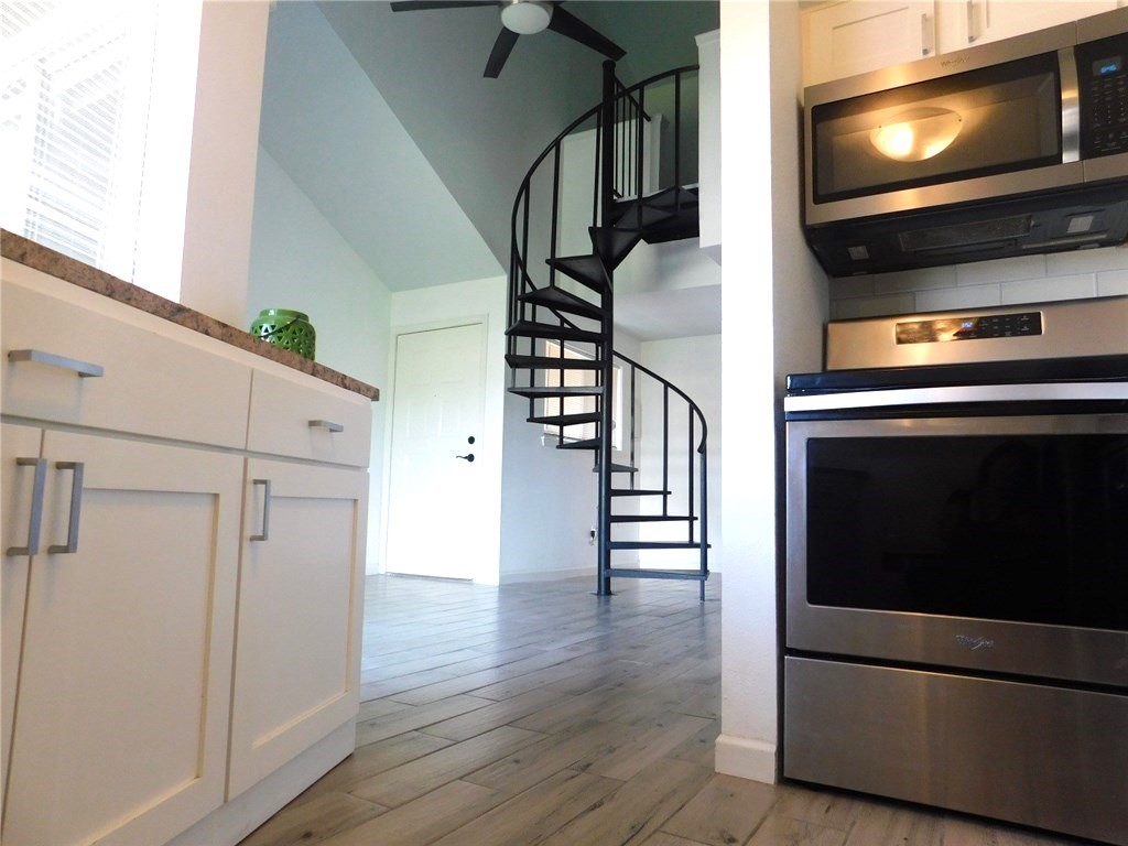 a view of hallway with wooden floor and stairs